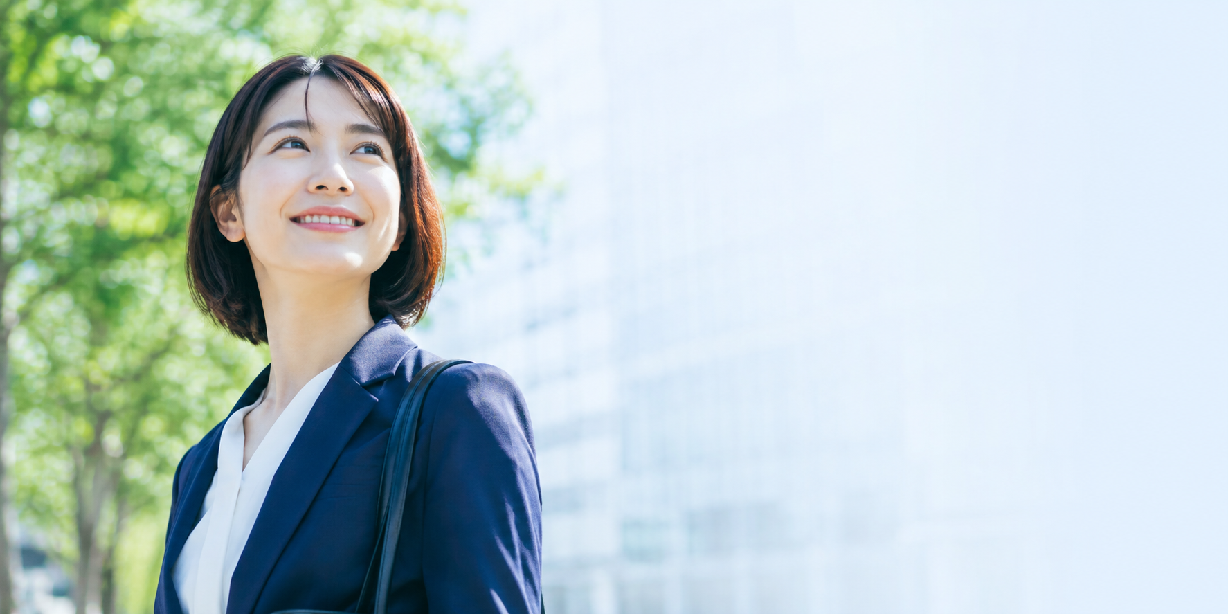 緑のある場所で微笑む女性